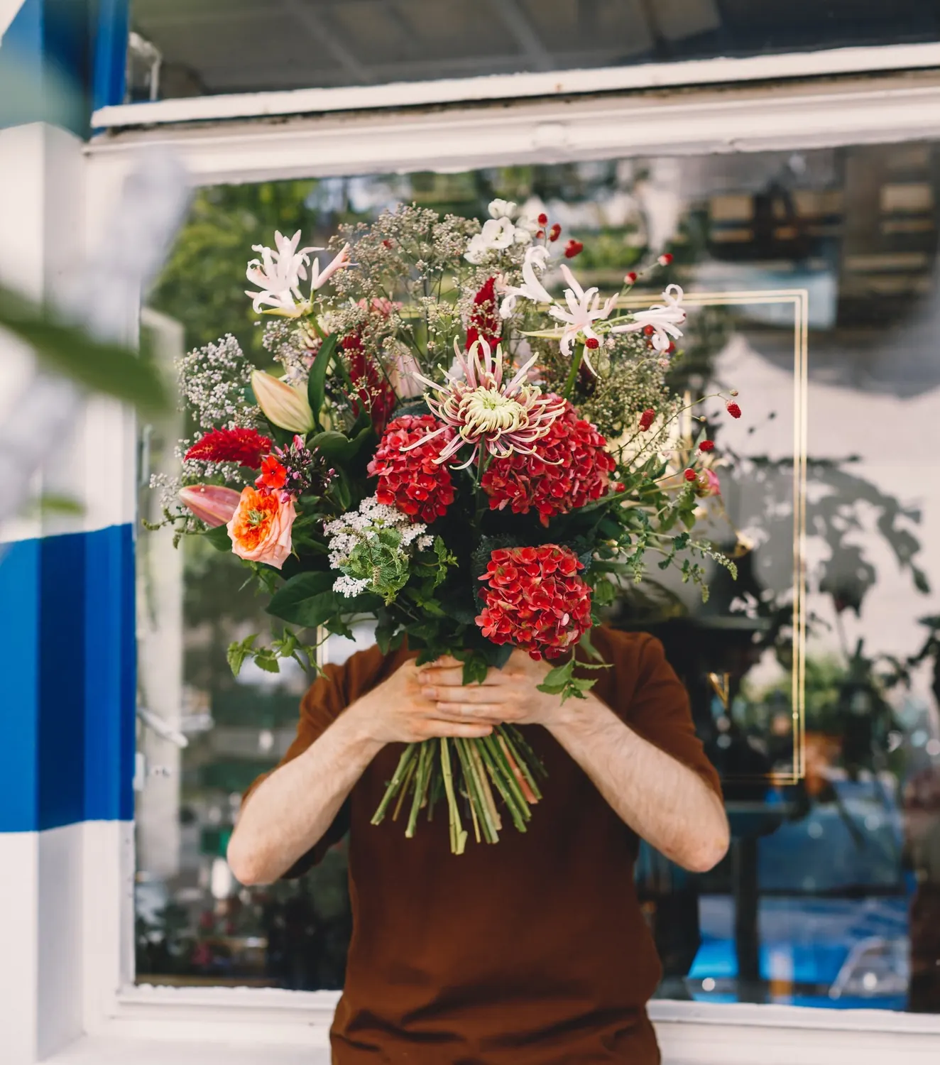Florist holding a large bouquet in front of their face