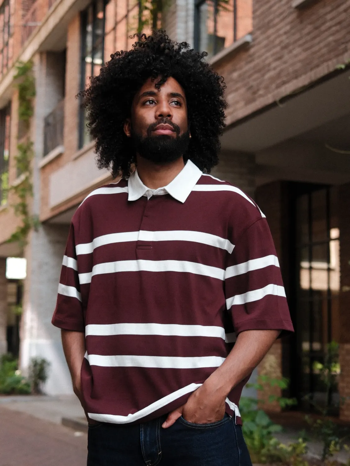Portrait of a man in a striped shirt against a warm wall